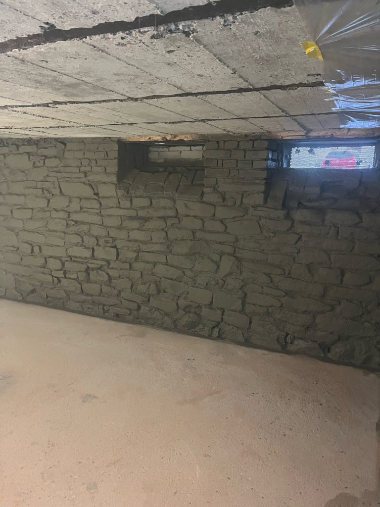 Kellerwand aus Bruchsteinmauerwerk mit aufgetragener K2 Zwischenschicht der Abdichtung