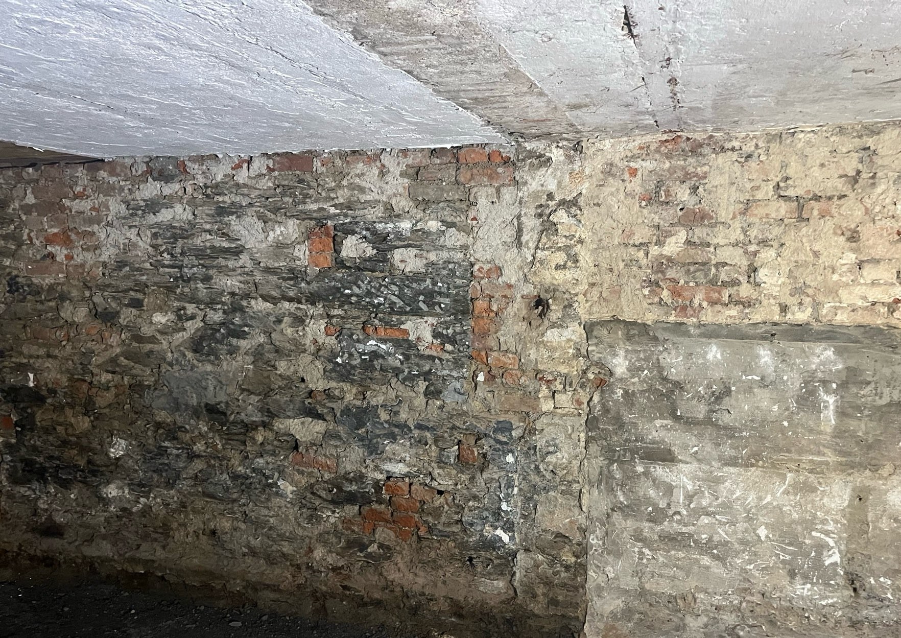 Feuchte Kellerwand aus Bruchsteinmauerwerk mit sichtbarer Durchfeuchtung